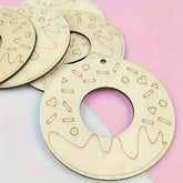 Wooden decorative plates with cut-out patterns on a pink and white background