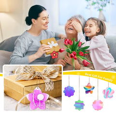 Family scene with a woman, child, and elderly person with flowers and a gift, accompanied by decorative items.