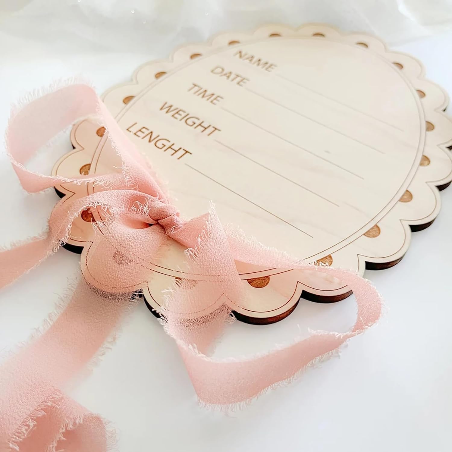 Heart-shaped wooden plaque with text and a pink ribbon on a white background