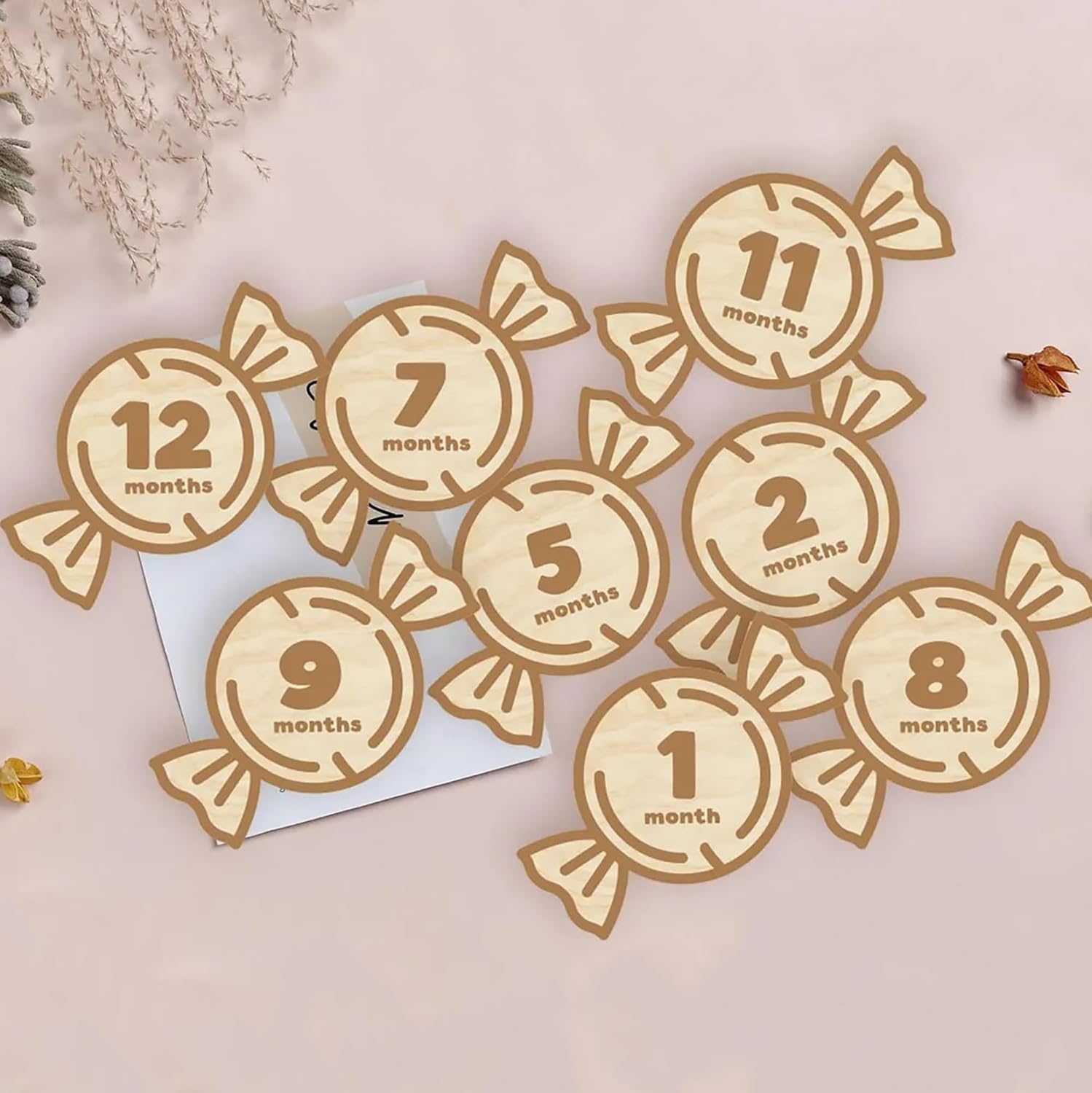 Wooden candy-shaped milestone markers with numbers on a light background