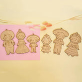 Set of wooden character cutouts on a pink and beige background