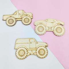 Three wooden toy truck models on a two-tone pink and white background