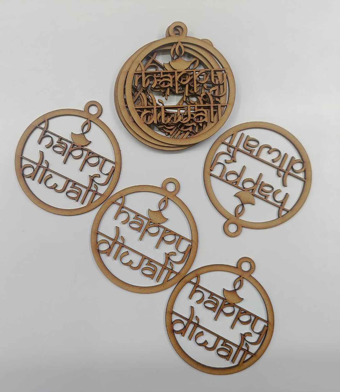 Five wooden 'Happy Diwali' decorative pendants on a white background