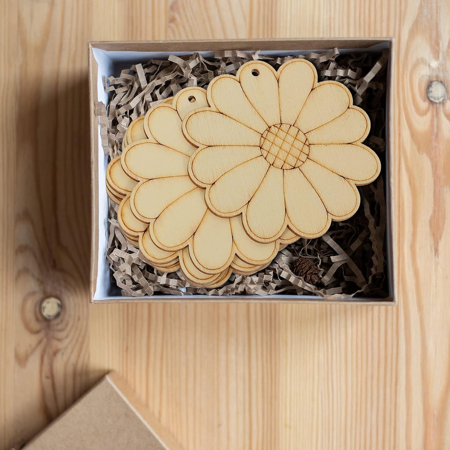 Wooden daisy-shaped items in a box on a wooden surface