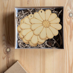 Wooden daisy-shaped items in a box on a wooden surface