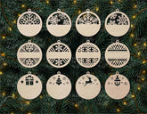Set of wooden Christmas ornaments with various cut-out designs on a green pine branch background.