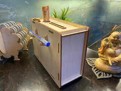 Wooden box with a blue marker on a dark surface with decorative items.