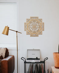 Decorative wall art above a record player in a room with a lamp and plant.