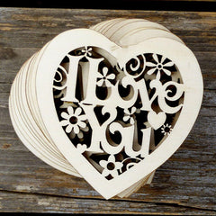 Wooden heart-shaped cutout with 'I Love You' text on a wooden surface