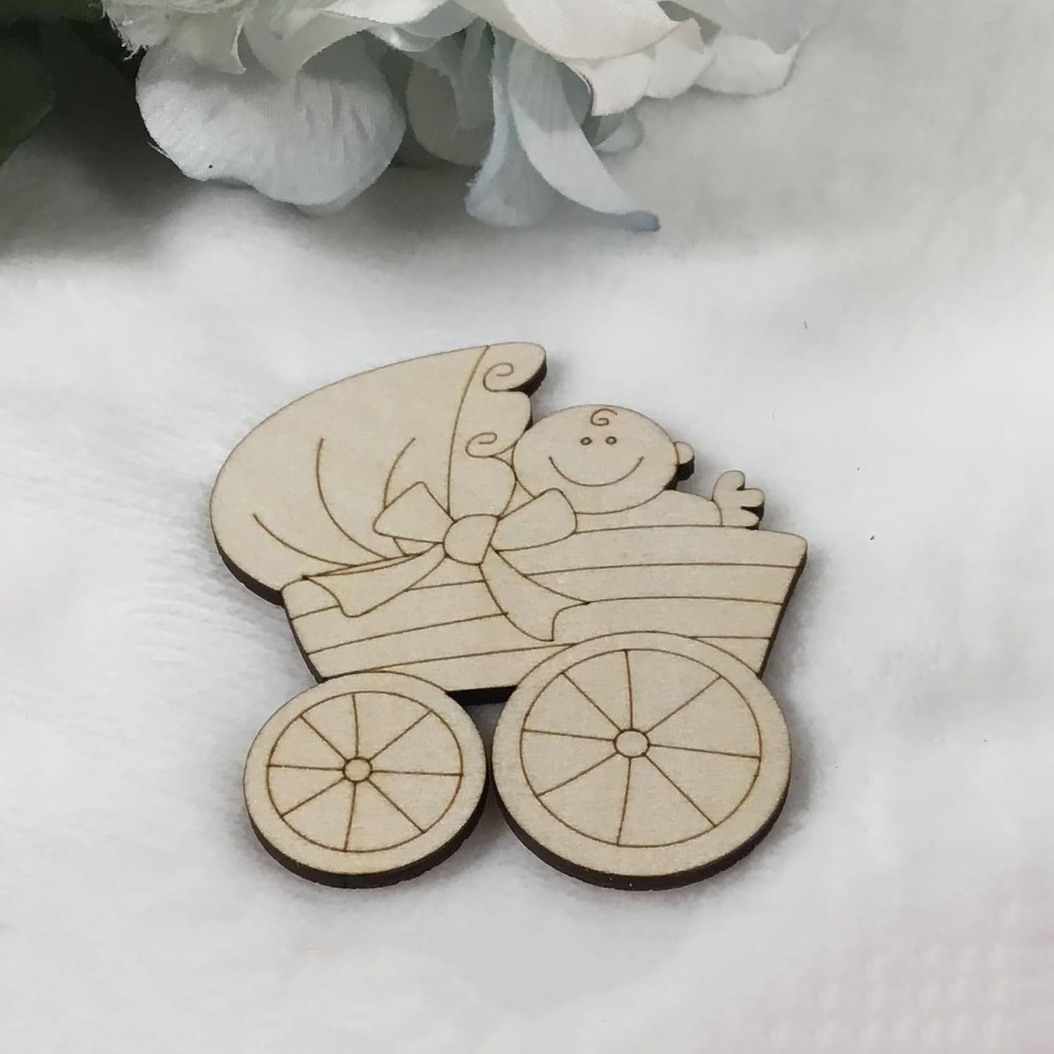 Wooden baby carriage ornament with a baby inside on a white background