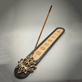Incense stick with a decorative holder featuring lotus designs on a gray background