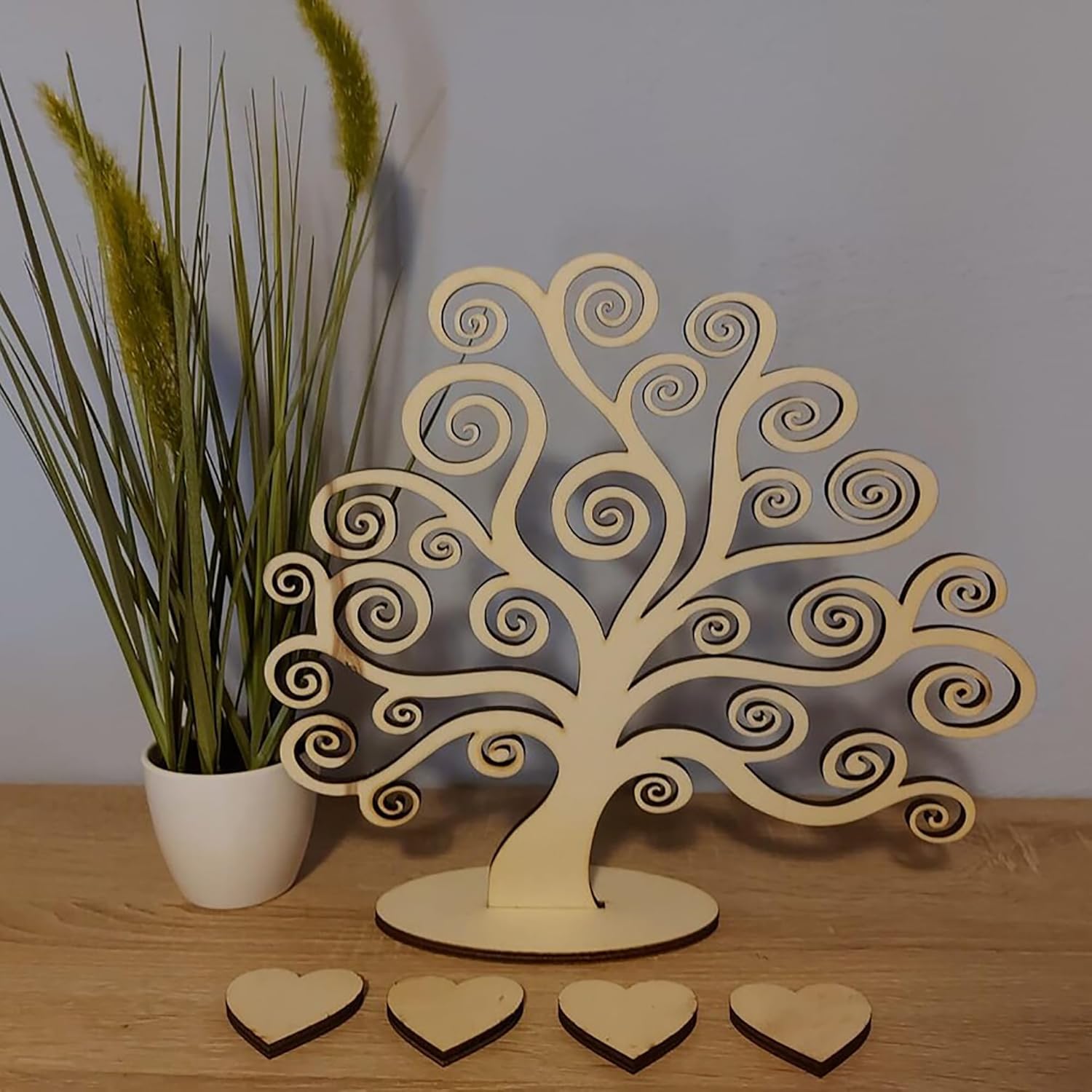Wooden tree-shaped jewelry organizer with heart-shaped items on a wooden surface.