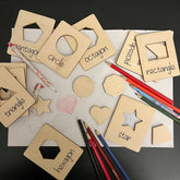 Wooden shape sorting toys with labeled shapes and pencils on a black background