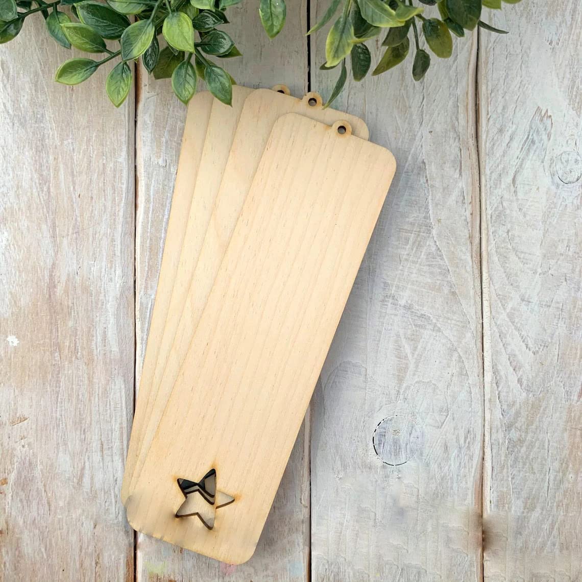 Set of wooden bookmarks with star cutout on a rustic wooden surface.