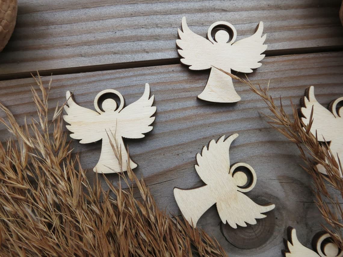 Wooden angel cutouts on a wooden surface with grass.