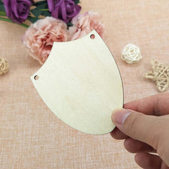 Hand holding a beige paper cutout with floral decorations in the background