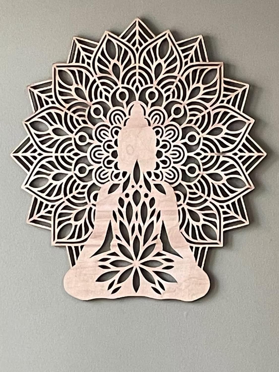 Decorative wall art with a mandala design and Buddha silhouette on a gray background