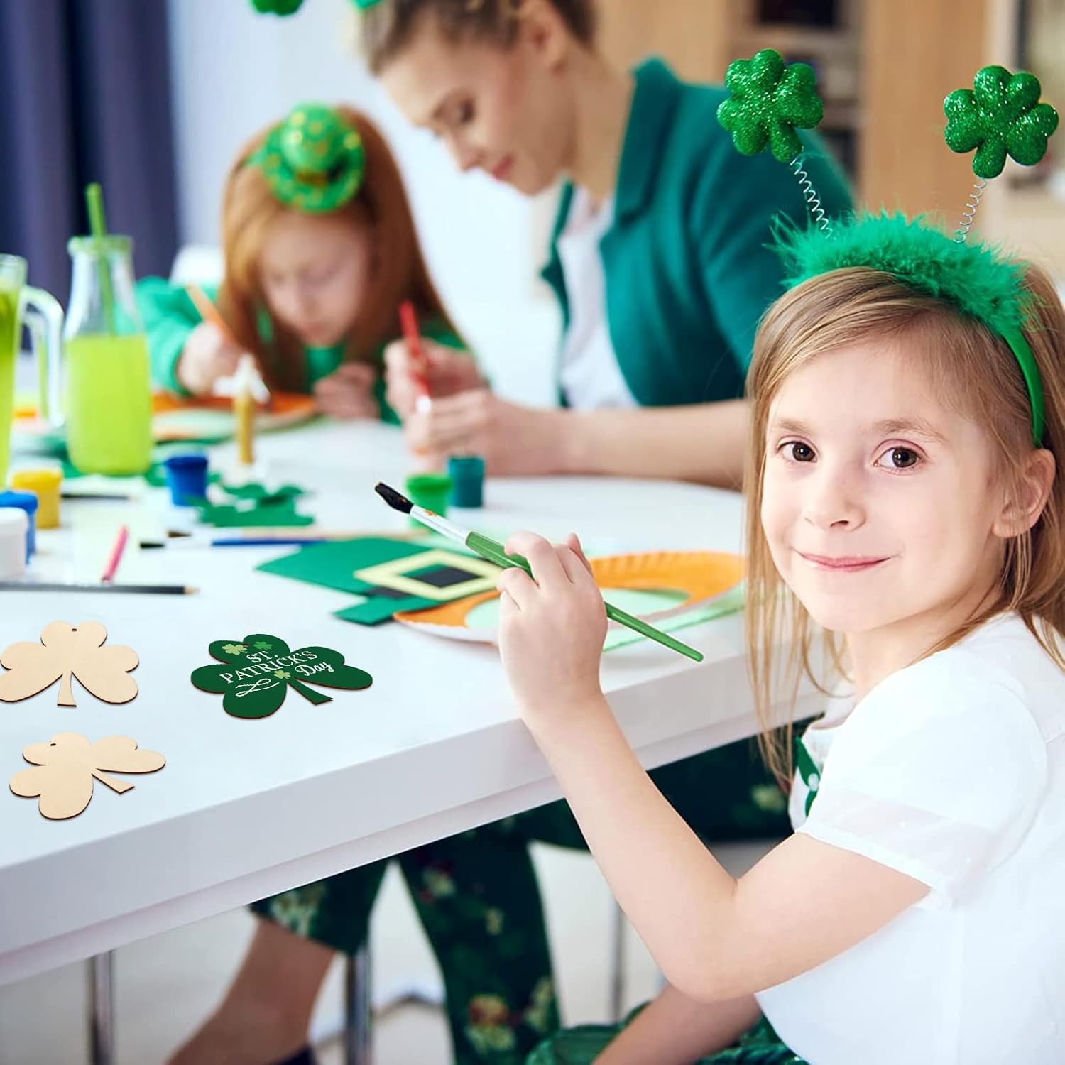 Children with shamrock decorations and a child painting at a table.