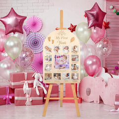 Decorative setup for a baby's first birthday with balloons, gifts, and a photo collage board.