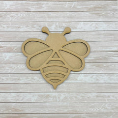 Wooden bee-shaped cutout on a wooden surface