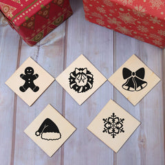 Set of Christmas-themed rubber stamps on a wooden surface with gift boxes in the background.