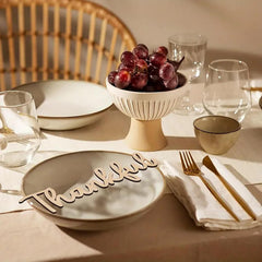Dining table setting with a bowl of grapes, glasses, and a 'Thankful' sign.