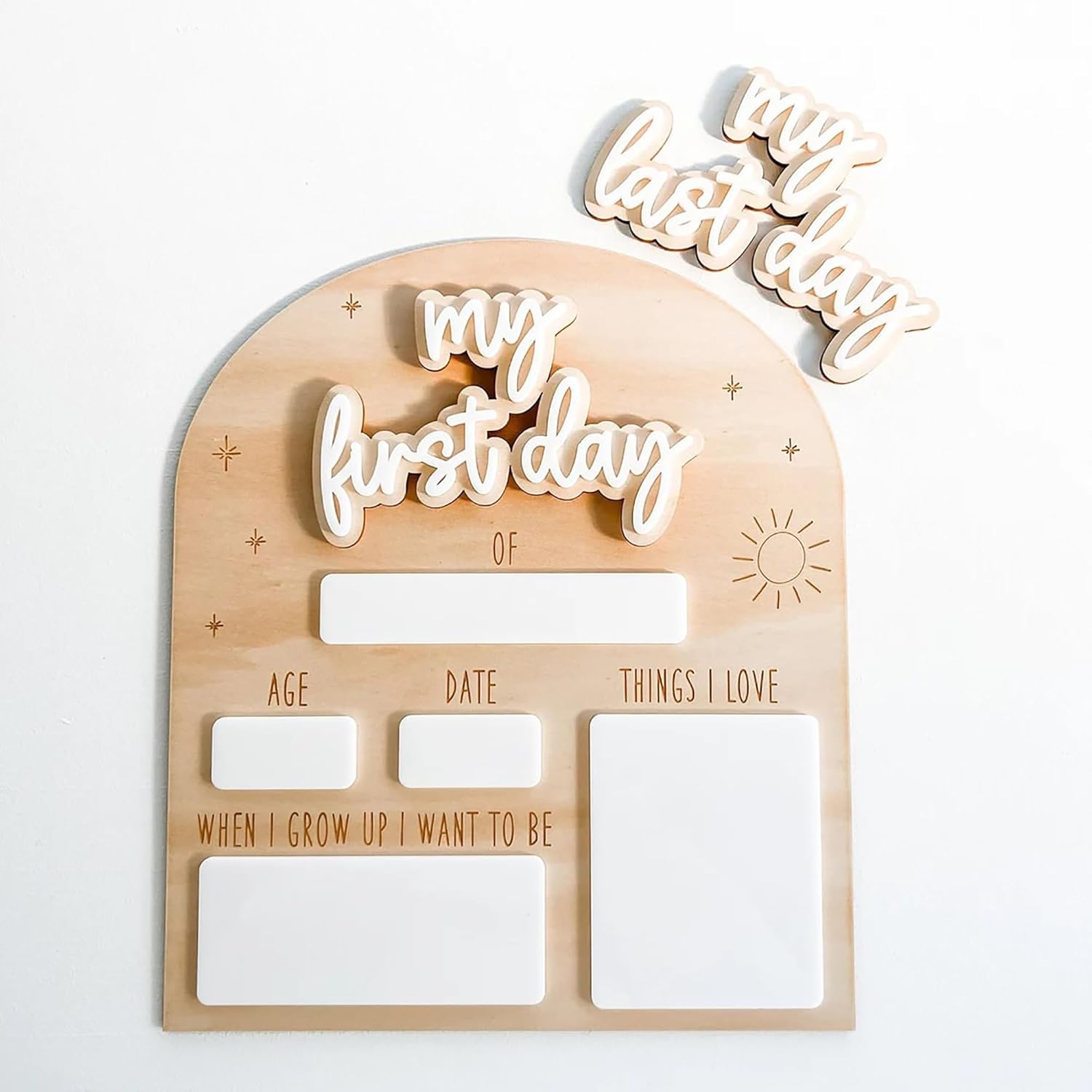 Wooden plaque with cut-out letters spelling 'my first day' and other text on a white background