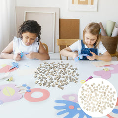 Two children sitting at a table with craft materials and alphabet letters.