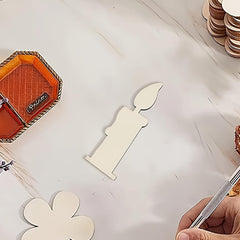 White paper cutout of a candle with a pen on a white surface