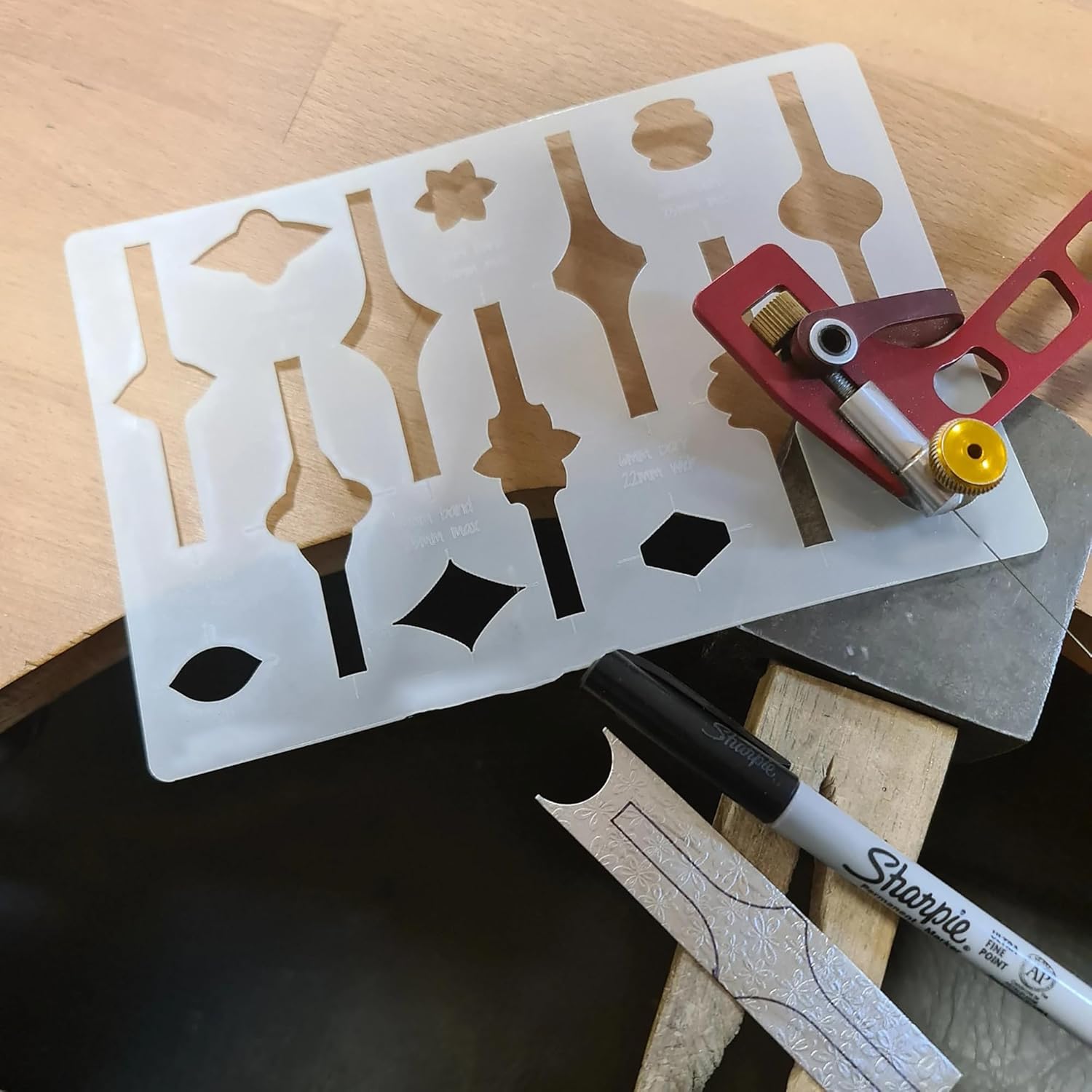 Stencil with various shapes on a wooden surface with a Sharpie marker.