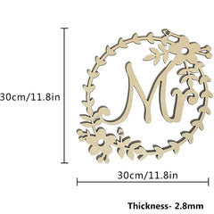 Decorative wooden letter 'M' with floral wreath and measurements on a white background