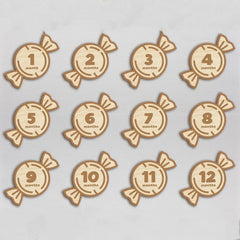 Wooden baby milestone markers with numbers 1 to 12 months on a light gray background