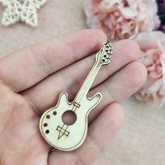 Wooden guitar-shaped pin held in a hand with a floral background