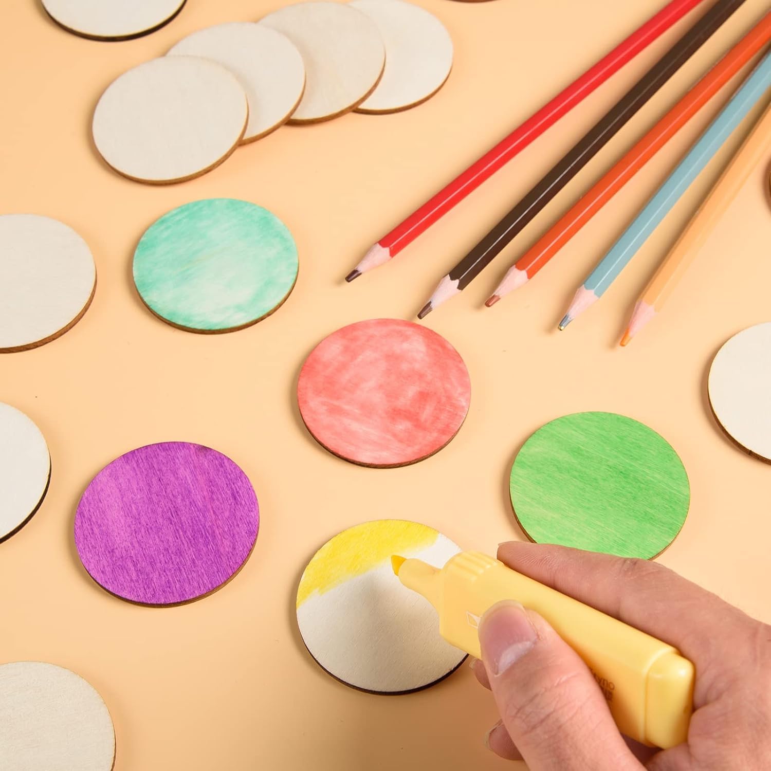Colorful circular markers and pencils on a beige background