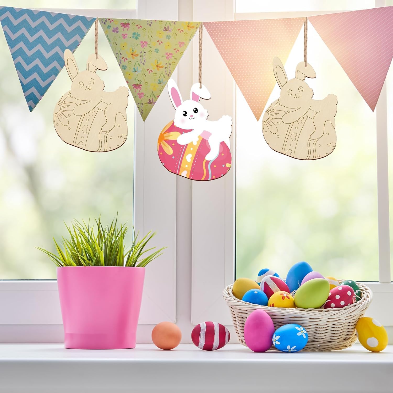 Decorative Easter scene with bunny-shaped wooden signs, colorful eggs, and a pink pot on a windowsill.