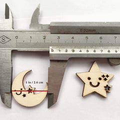 Wooden moon and star shapes with smiley faces on a white background, measured by a caliper.