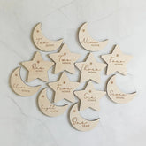 Wooden baby milestone markers with months engraved on a light background