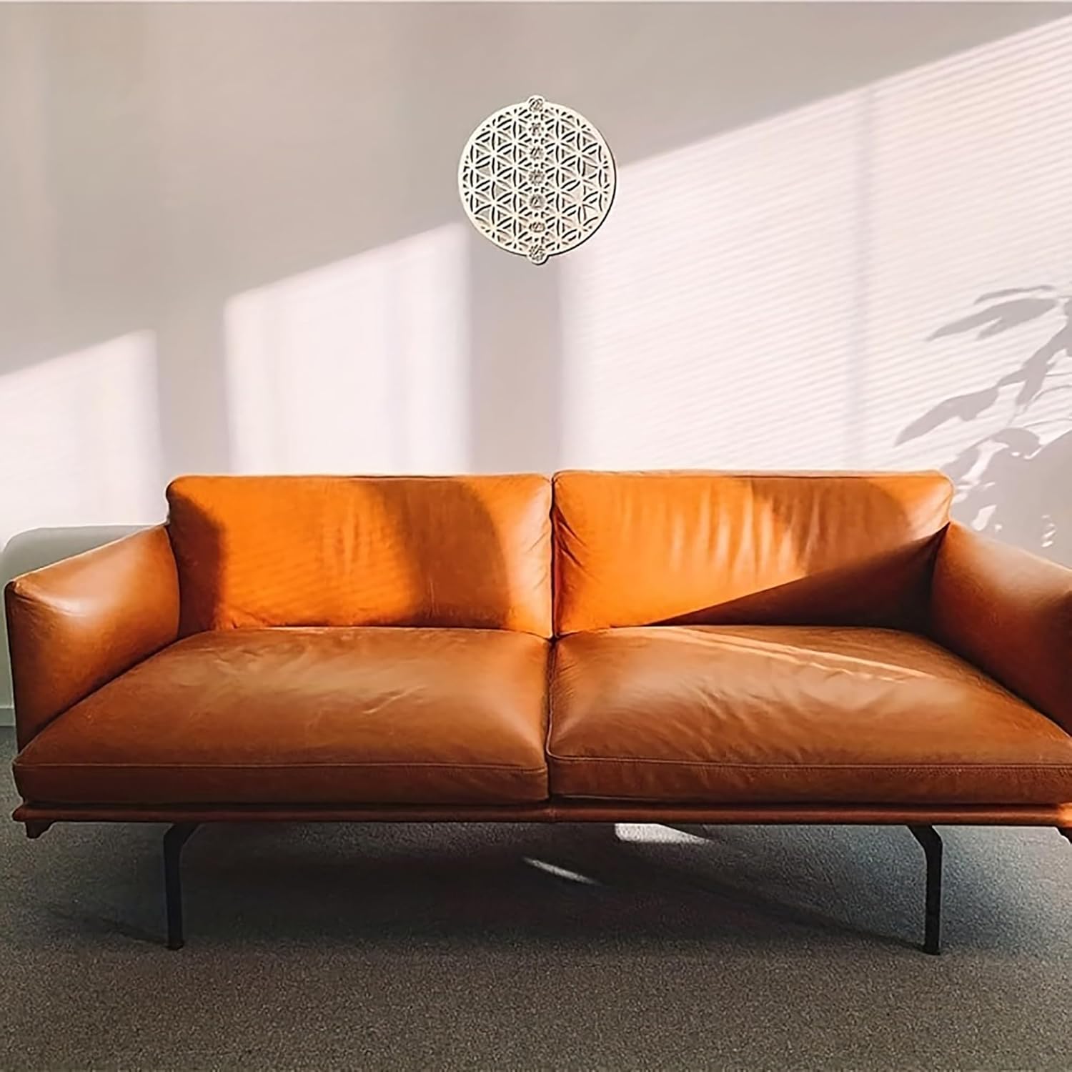 Brown leather sofa in a room with sunlight filtering through blinds