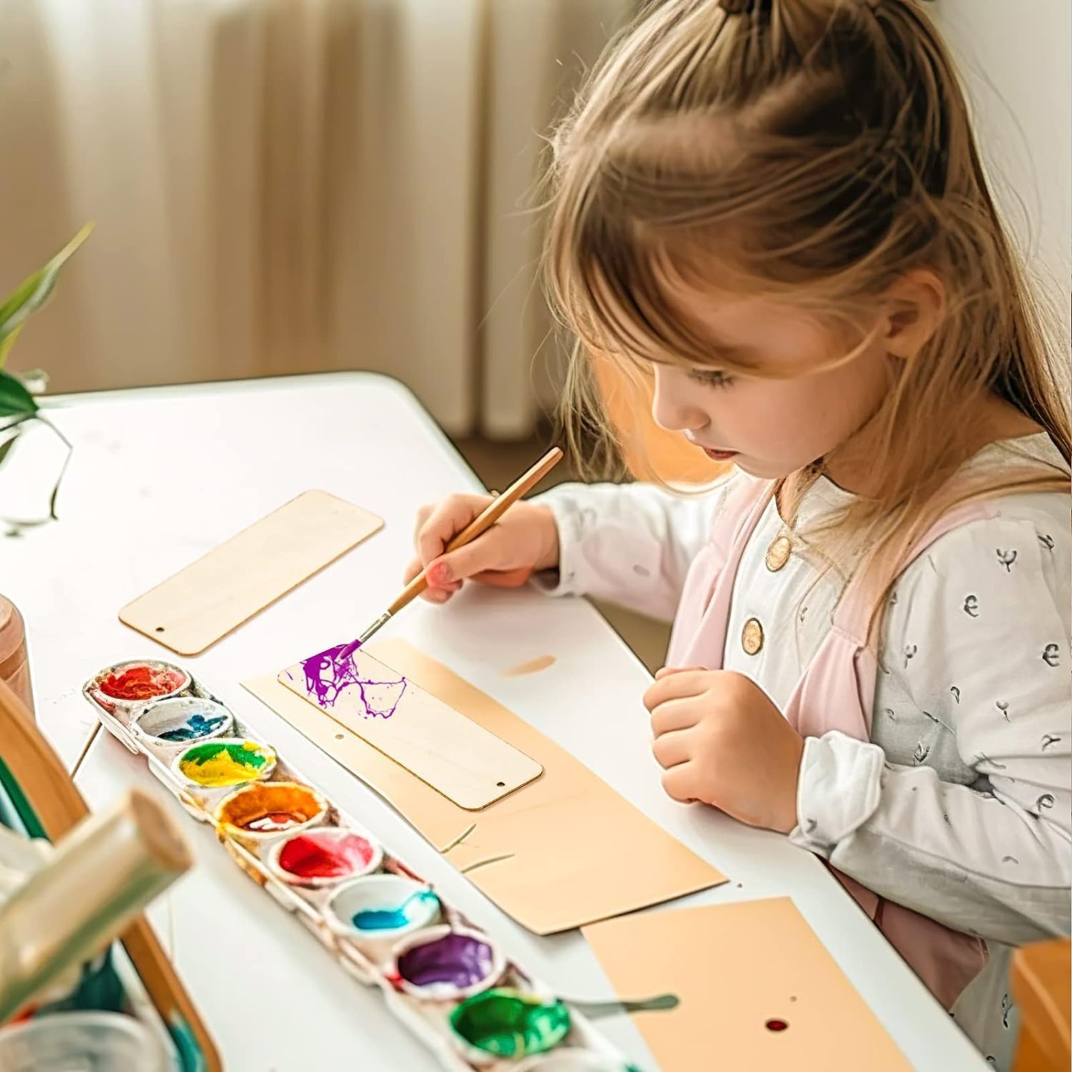Child painting with watercolors at a table
