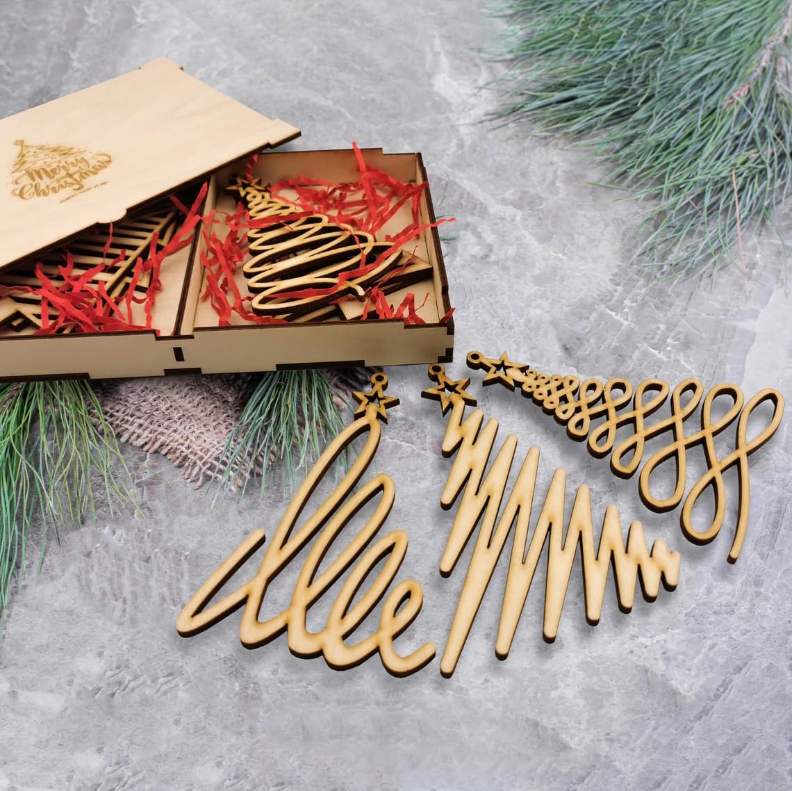Wooden Christmas decorations with 'Merry Christmas' text on a textured surface with greenery.