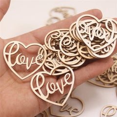 Wooden heart-shaped decorations with 'love' engraving held in a hand.