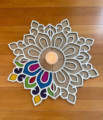Decorative wall art with a candle in the center on a wooden floor