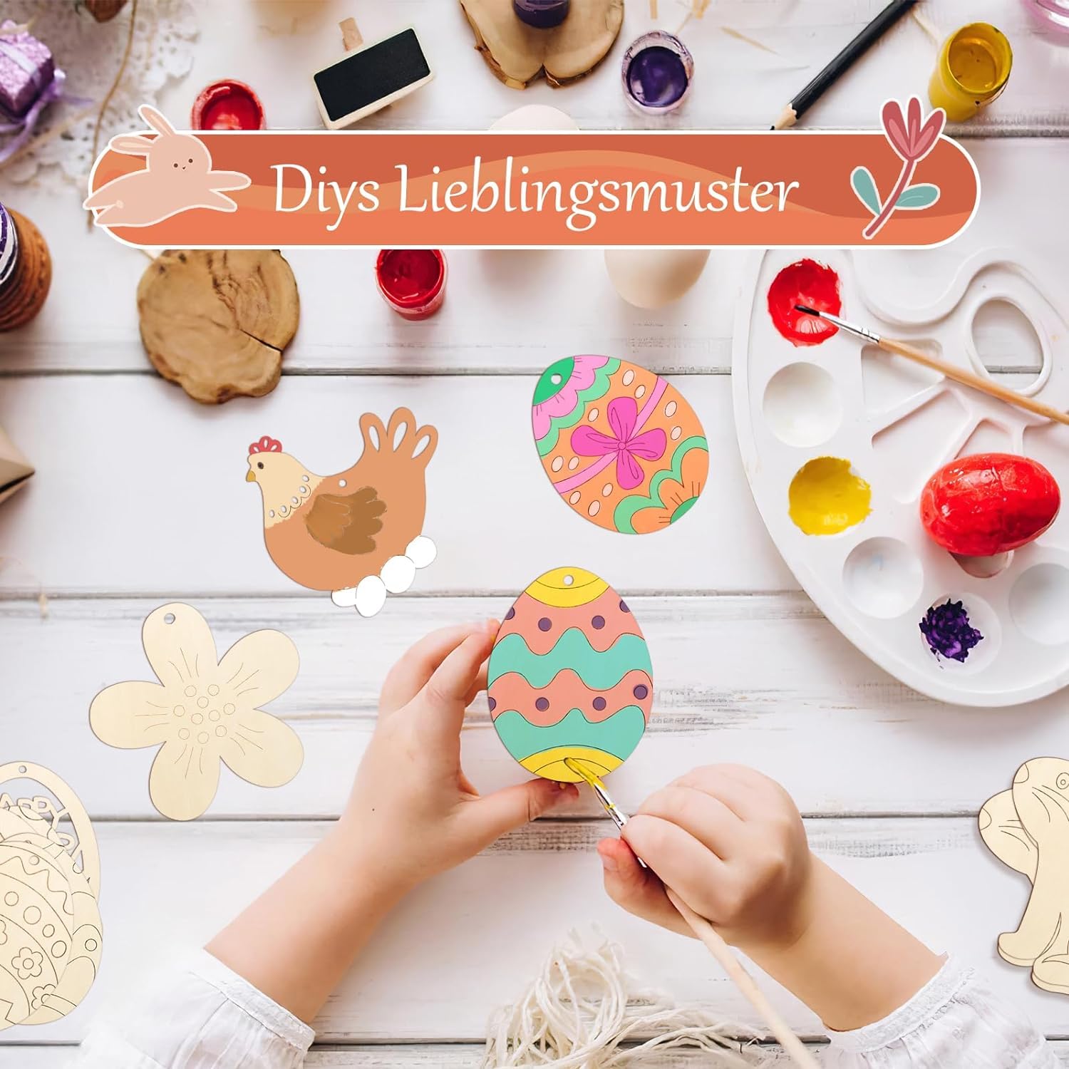Children's hands painting wooden Easter eggs with a palette and decorative items on a wooden surface.