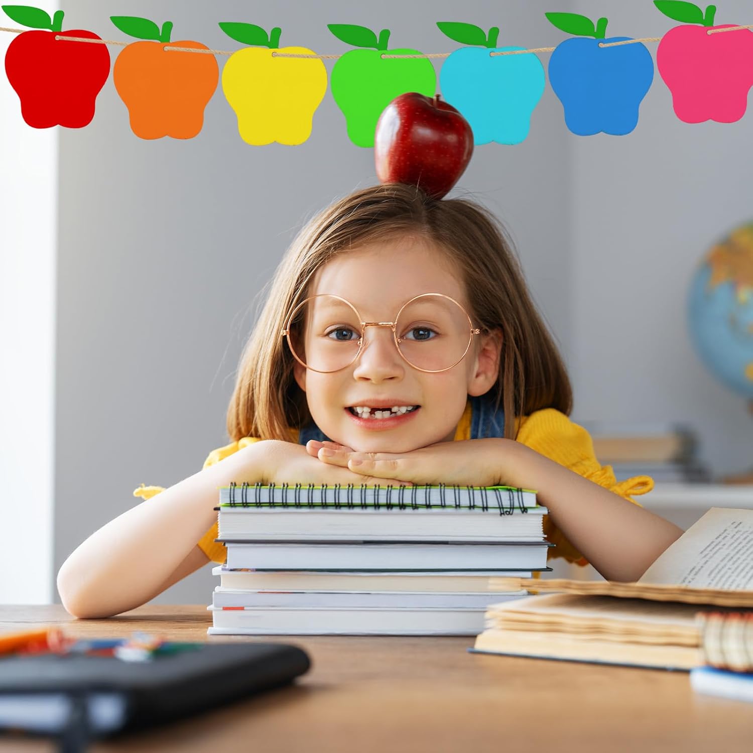 Child with books and an apple on head in a classroom setting