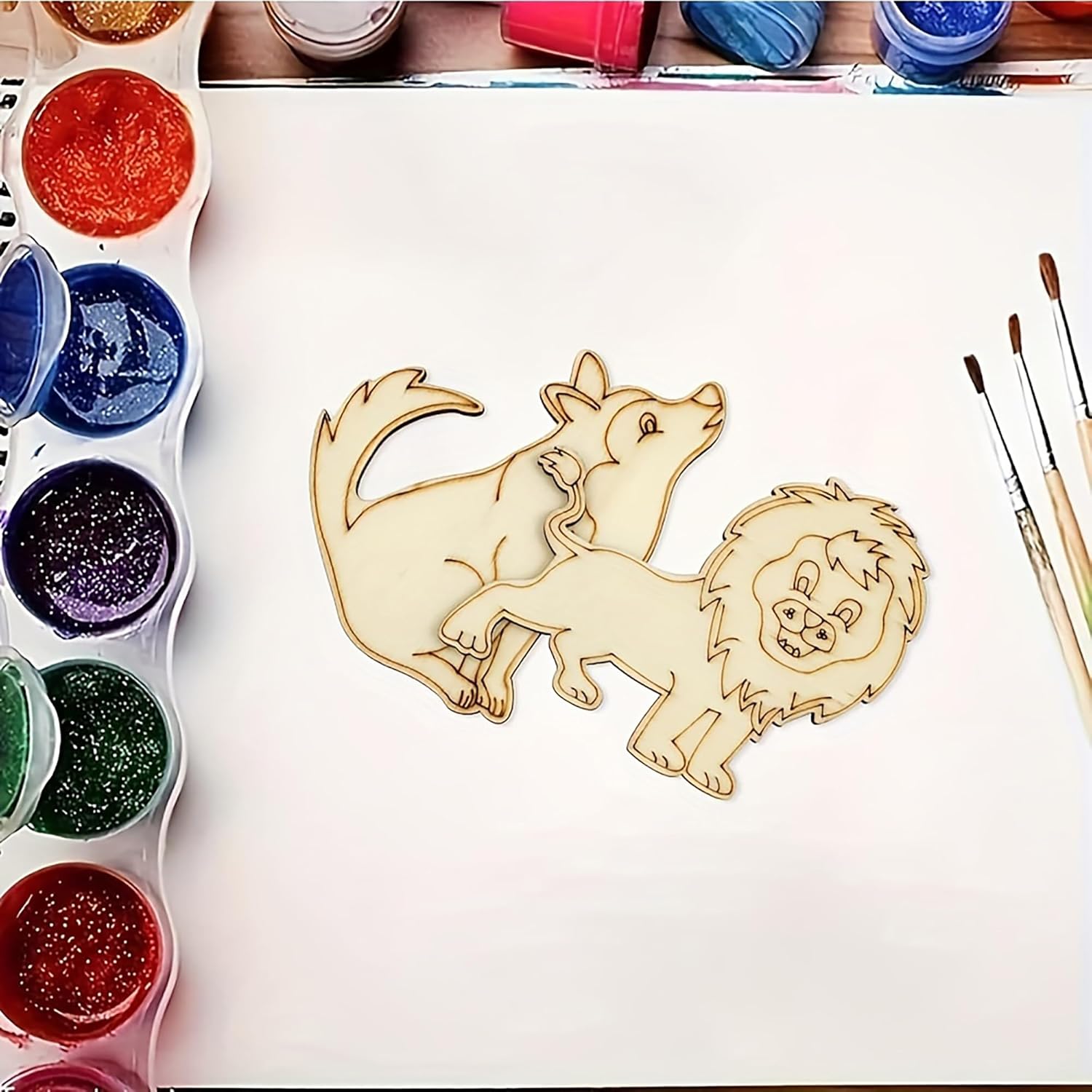 Wooden cutout of a lion and a dog with paint supplies on a table