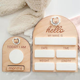 Wooden baby milestone boards with 'hello my name is' and 'today I am' text on a soft surface.