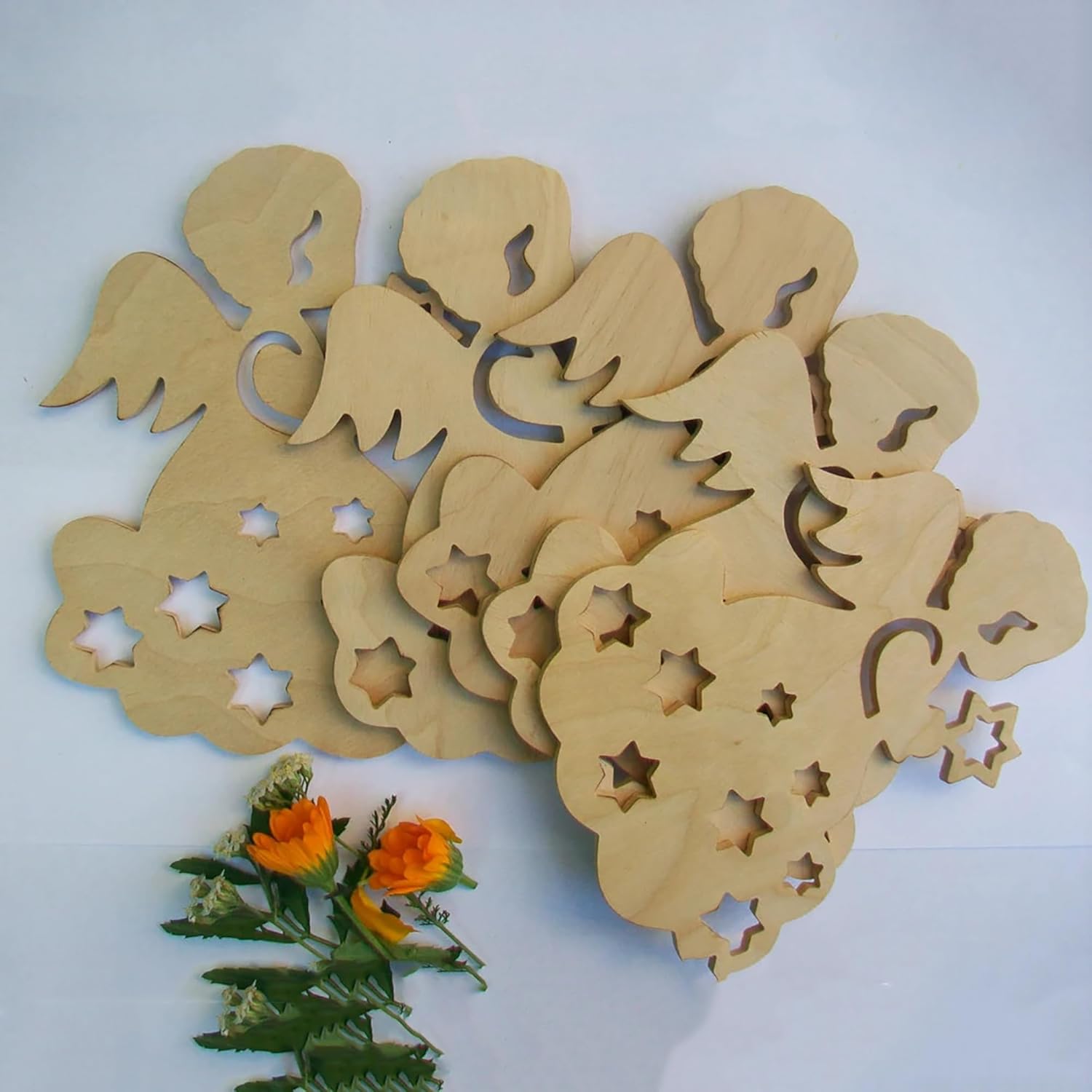 Wooden angel cutouts with star and moon designs on a white background