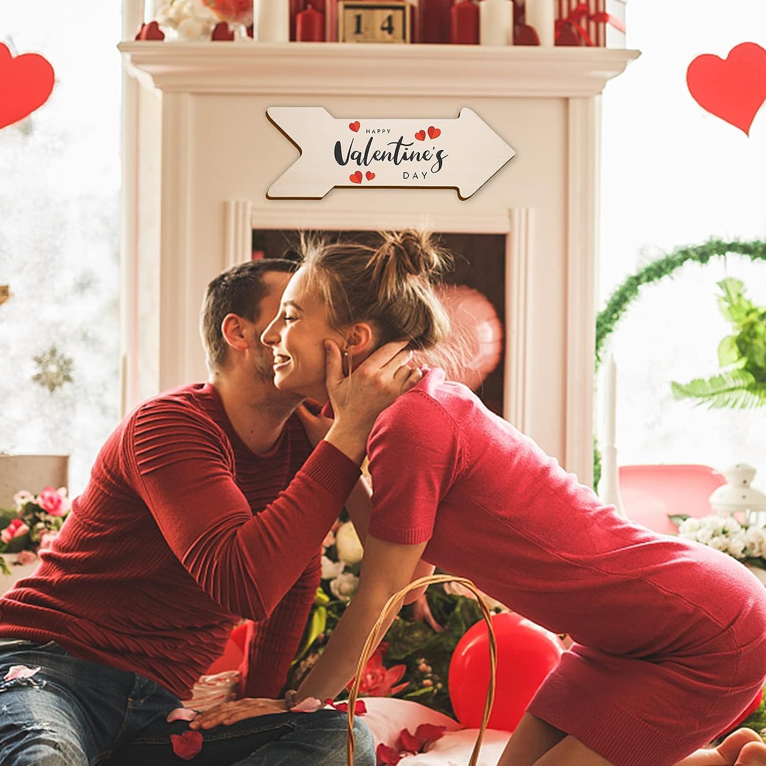 Couple in red clothing sitting close together in a decorated room with Valentine's Day decorations.