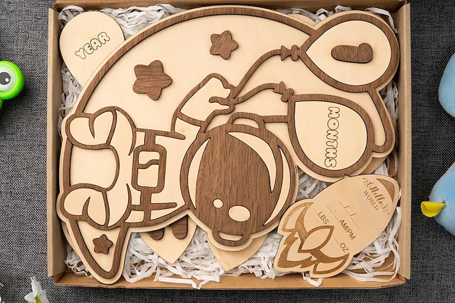 Wooden cutouts with engraved designs in a box on a textured surface
