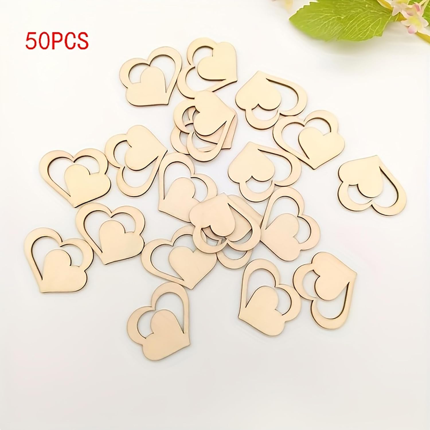 50 wooden heart-shaped items on a white background with green leaves.